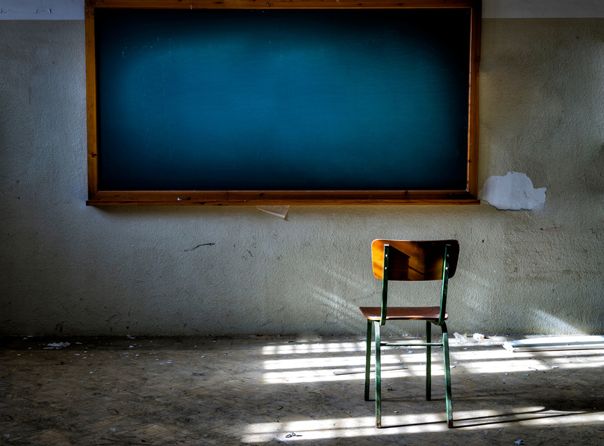 Abandoned Classroom with Chair in Front of the Vintage Blackboard