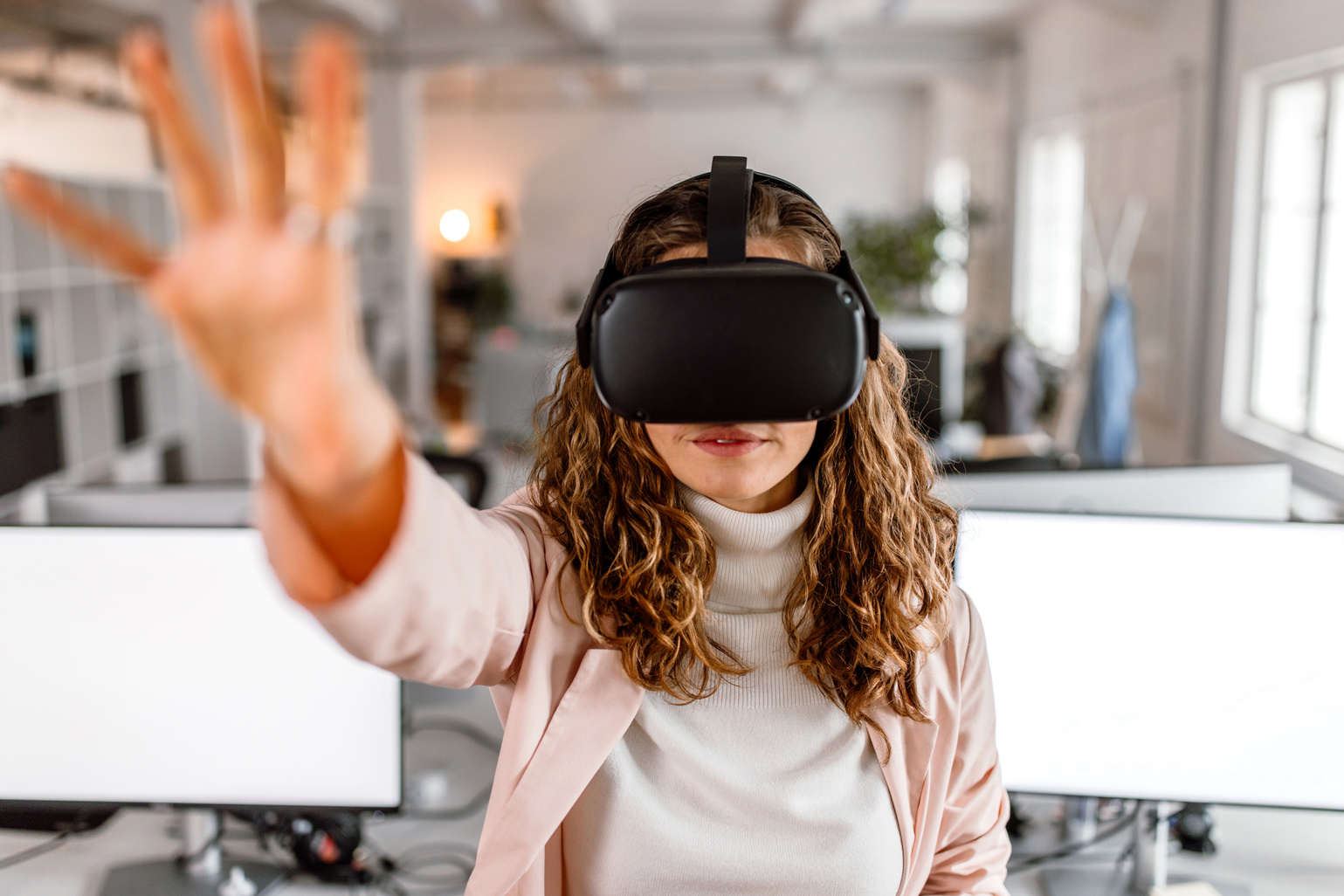 Woman using VR goggles and enjoying new vr simulation in the office